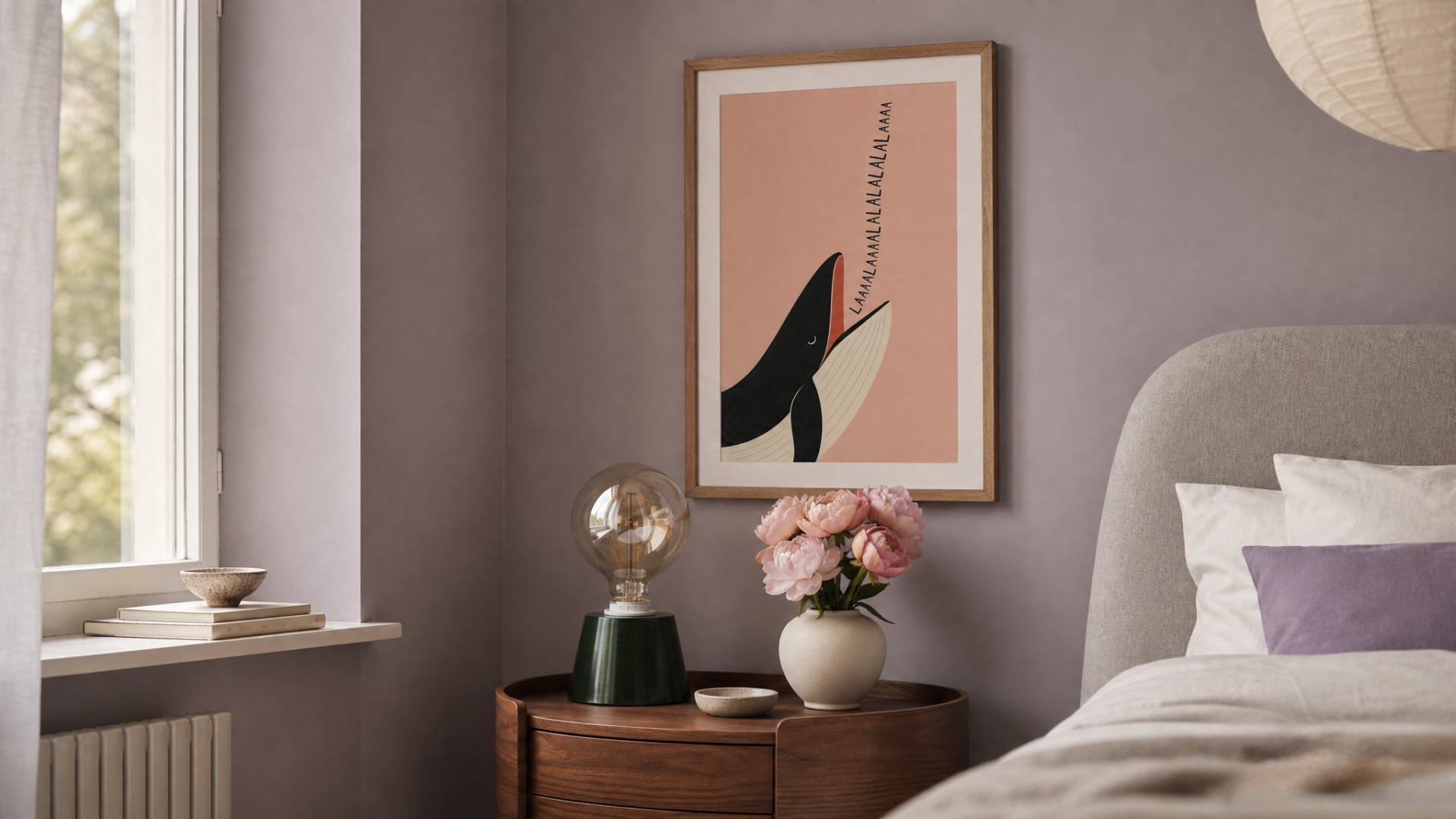 A serene bedroom corner in dusty lavender with a framed whimsical whale poster above a curved walnut bedside table, blush peonies in an ivory vase, and a warm glowing bulb lamp.